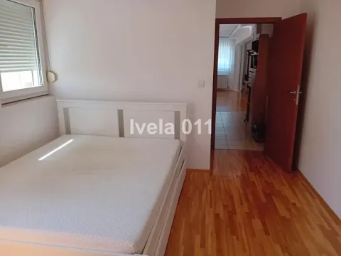 Spavaća soba sa belim krevetom i drvenim podom. - image 14