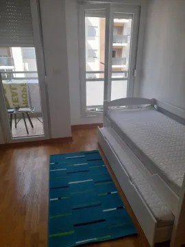 Bright bedroom with a pull-out bed and balcony access. - image 2