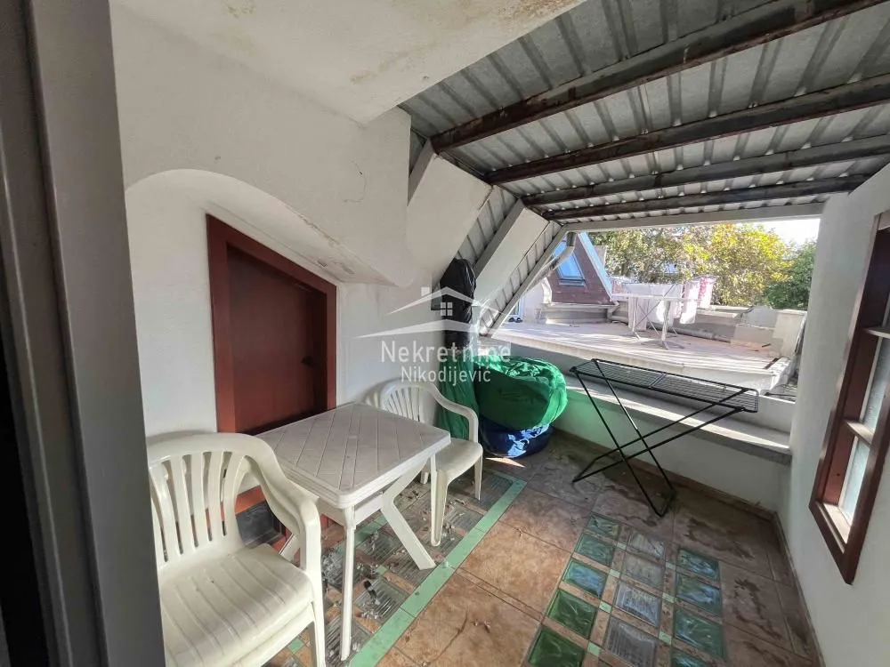 Covered terrace with a table, chairs, and access to the open part of the terrace.