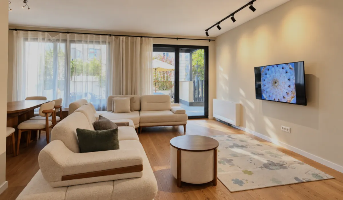 Spacious living room with a sofa set, dining area, and access to the terrace.