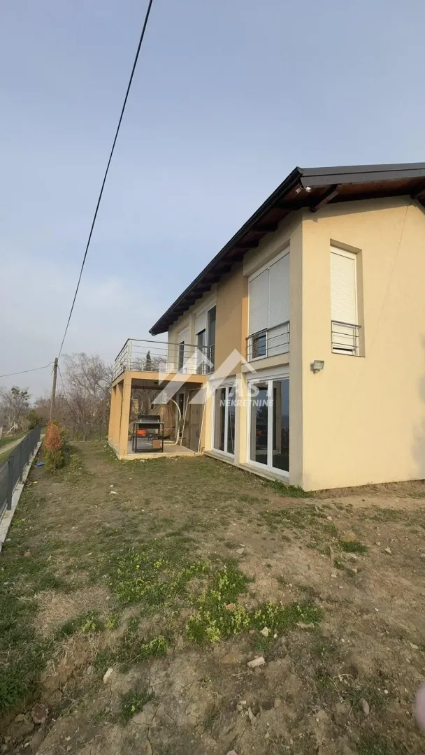 View of the exterior of the house with a yard and terrace.