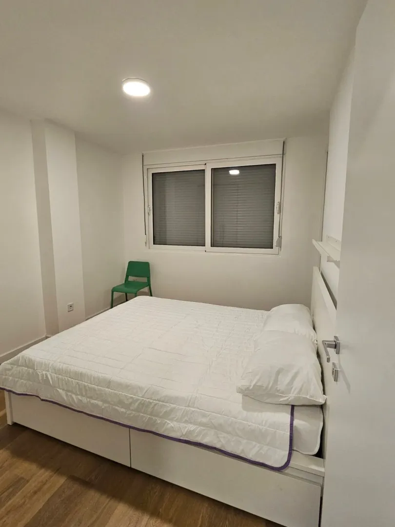 Bright bedroom with a double bed and a window.