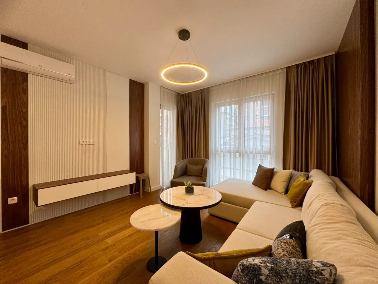 Modern and tidy living room with a sofa, coffee tables, and lighting.