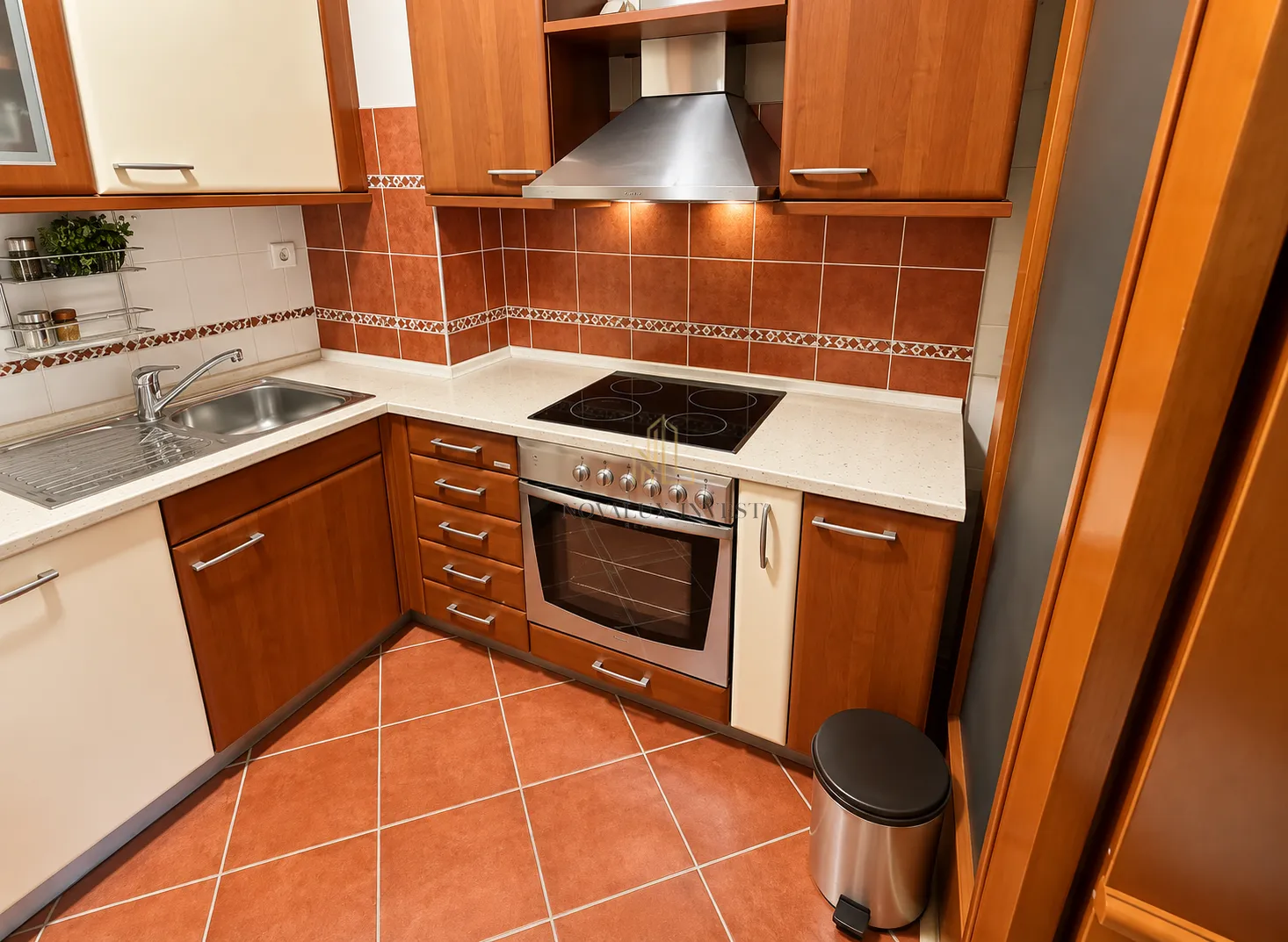 Kitchen with wooden cabinetry, built-in oven, and sink.