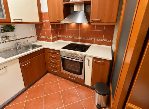 Kitchen with wooden cabinetry, built-in oven, and sink. - image 3