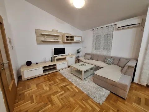 Dnevna soba sa ugaonom garniturom, televizorom i drvenim podom. - image 11