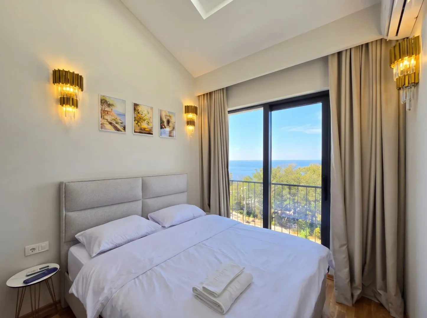 Spavaća soba sa bračnim krevetom i pogledom na more.