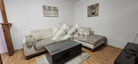 Dnevna soba sa ugaonom garniturom, stočićem i slikama na zidu. - image 2