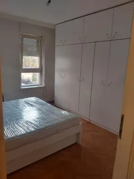 Spavaća soba sa krevetom i velikim belim ormarom. - image 6