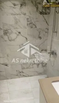 View of a modernly decorated bathroom with marble tiles and a shower cabin. - image 26