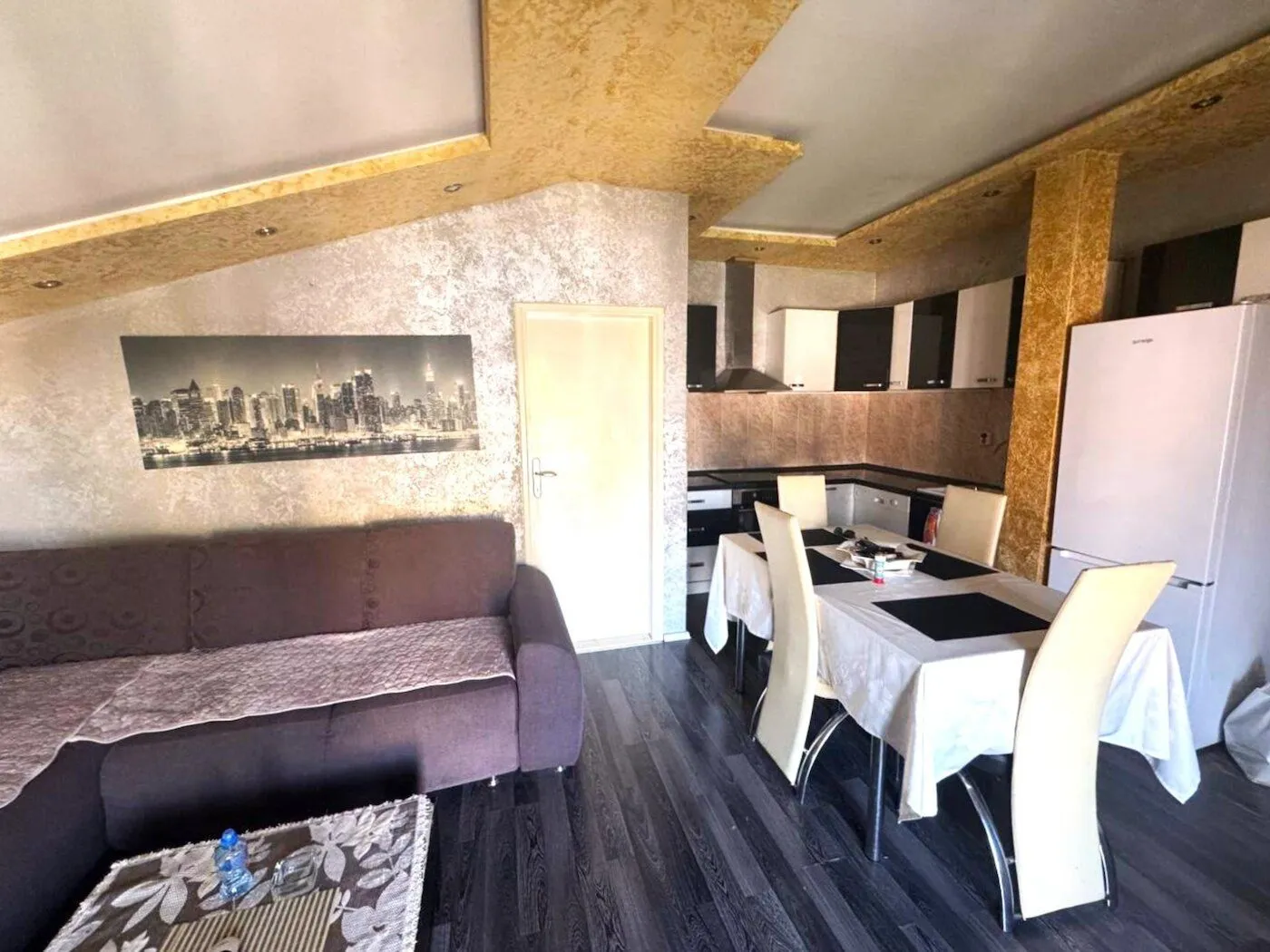 Living room with dining area and kitchen in the background.