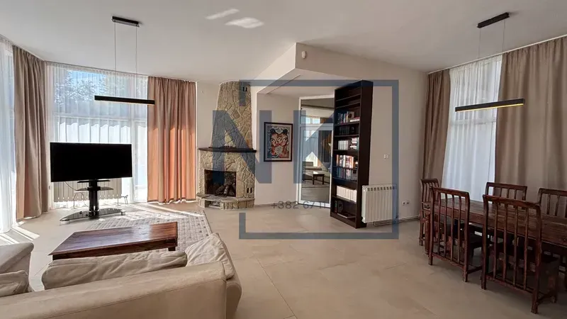 Spacious living room with a fireplace, TV, and dining area.