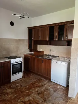 Kuhinja sa drvenim elementima, šporetom i mašinom za suđe. - image 8