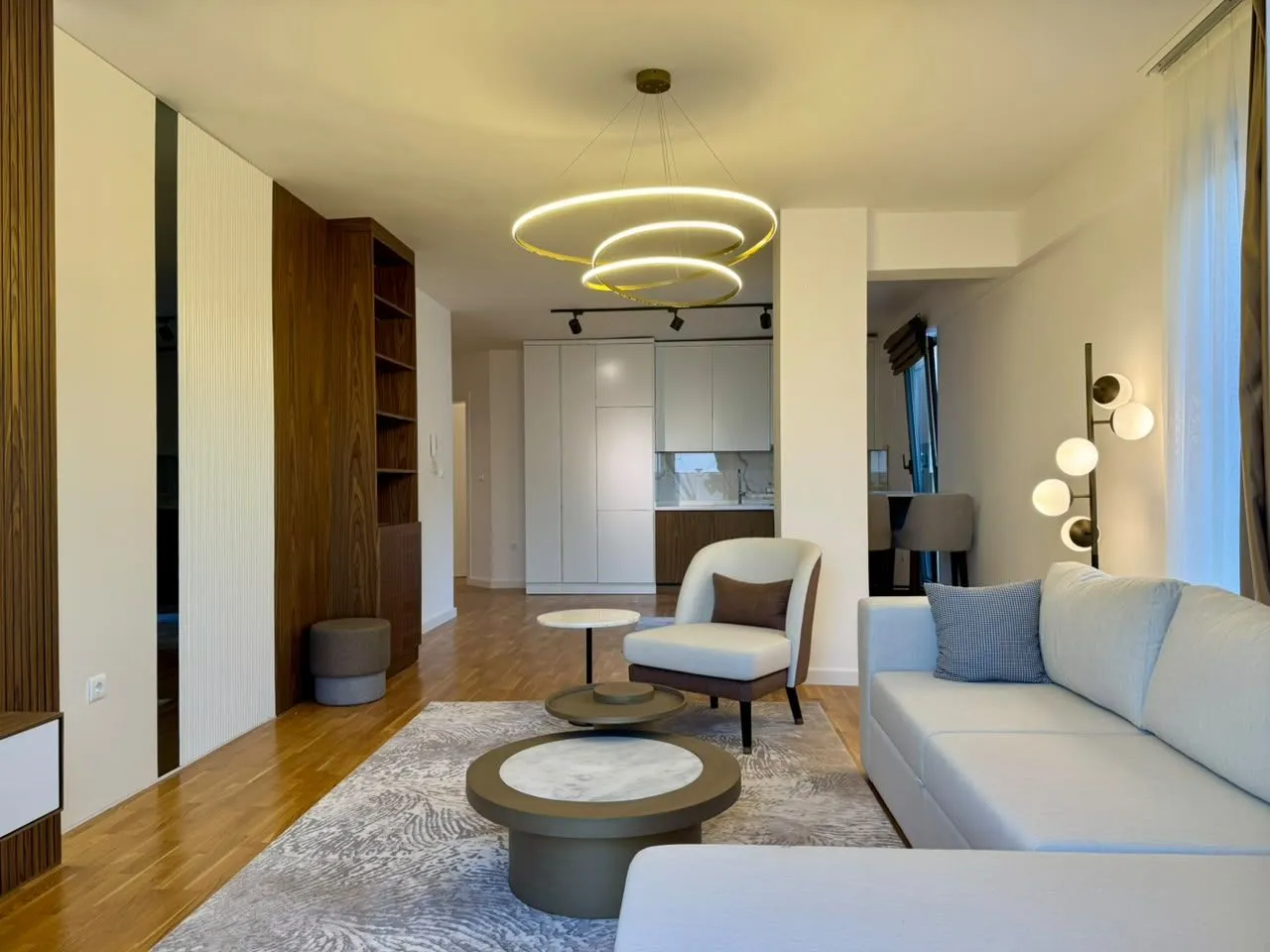 Modern and bright living room with a sofa and dining area in the background.