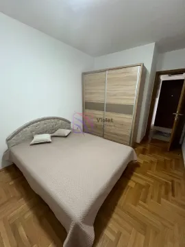 Spavaća soba sa bračnim krevetom, drvenim ormarom i parketom na podu. - image 7