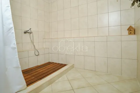 Shower cabin with ceramic tiles and a wooden grid on the floor. - image 8