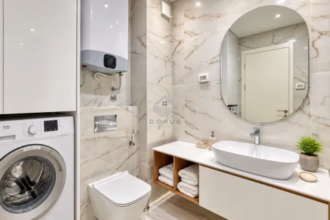 Modernly equipped bathroom with a washbasin, toilet, washing machine, and built-in water heater. - image 19
