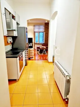 View from the hallway into the kitchen with ceramic tiles and a passage leading to the living room. - image 9
