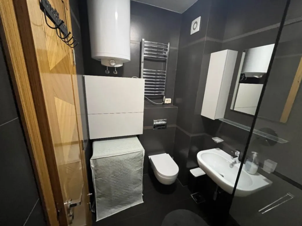 Savremeno opremljeno kupatilo sa tuš kabinom, umivaonikom i wc šoljom.