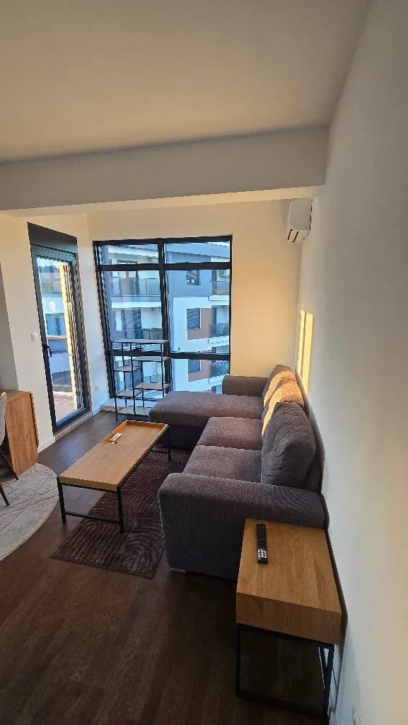 Living room with a sofa, coffee table, and window view.