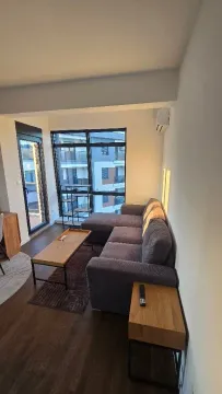 Living room with a sofa, coffee table, and window view. - image 9
