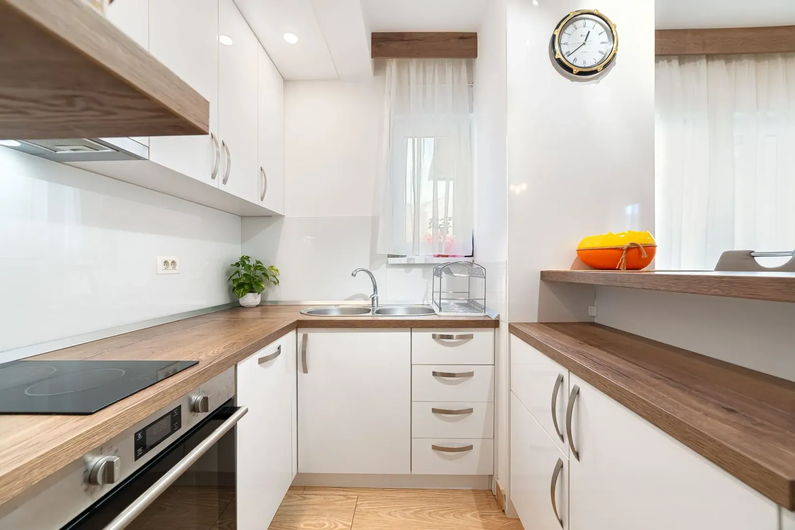 Modern kitchen with white cabinets and wooden countertops.