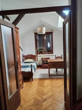 Bedroom with a wooden bed, a desk, and parquet flooring. - image 6