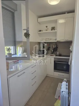 Small white kitchen with a built-in oven and a window. - image 6