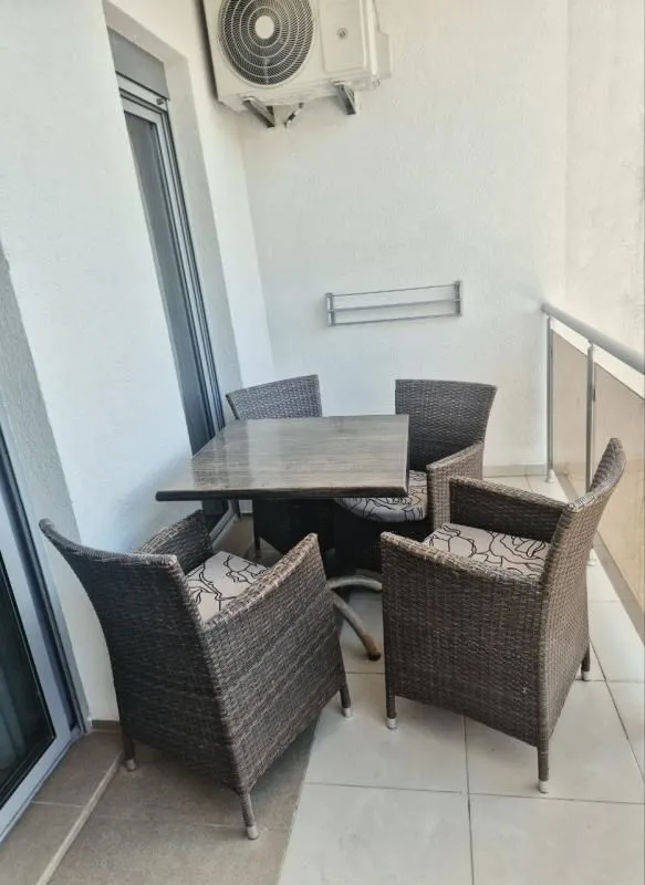 Covered terrace equipped with a dining table and armchairs.