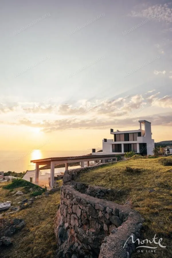 Exterior view of a modern house and yard during sunset.
