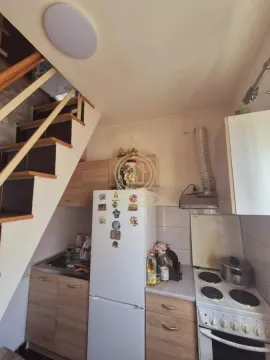 Manja kuhinja sa drvenim elementima i stepeništem pored. - image 5