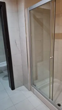 Bathroom with a glass shower cabin and light tiles. - image 12