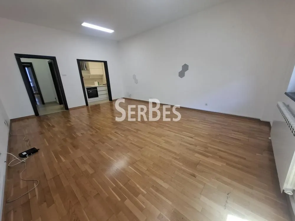 Empty room with wooden parquet flooring and white walls.
