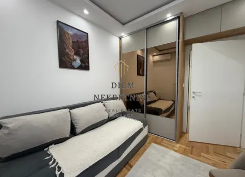Living room with a sofa and a large built-in wardrobe with a mirror. - image 8