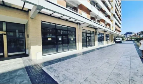 Exterior of a modern building with commercial spaces on the ground floor. - image 2