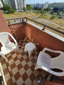 Small balcony with seating furniture and a view of the surroundings. - image 13