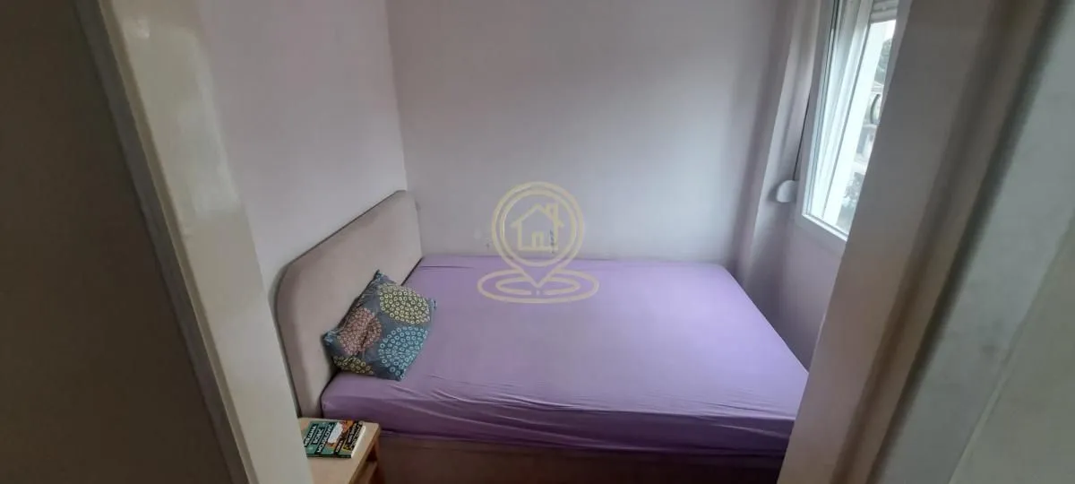 Manja spavaća soba sa bračnim krevetom i prozorom.