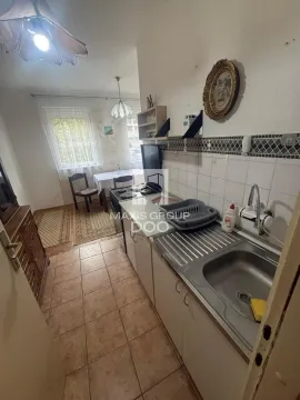 Manja kuhinja sa sudoperom, šporetom i trpezarijskim delom u pozadini. - image 10