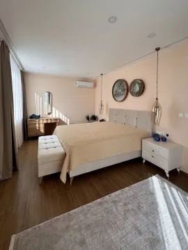 Spacious bedroom with a double bed, dresser, and nightstands. - image 2