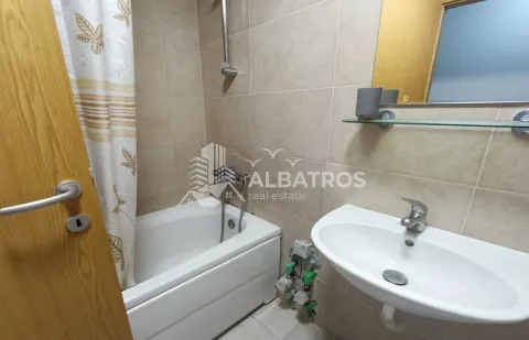 Bathroom equipped with a bathtub, washbasin, and mirror. - image 7