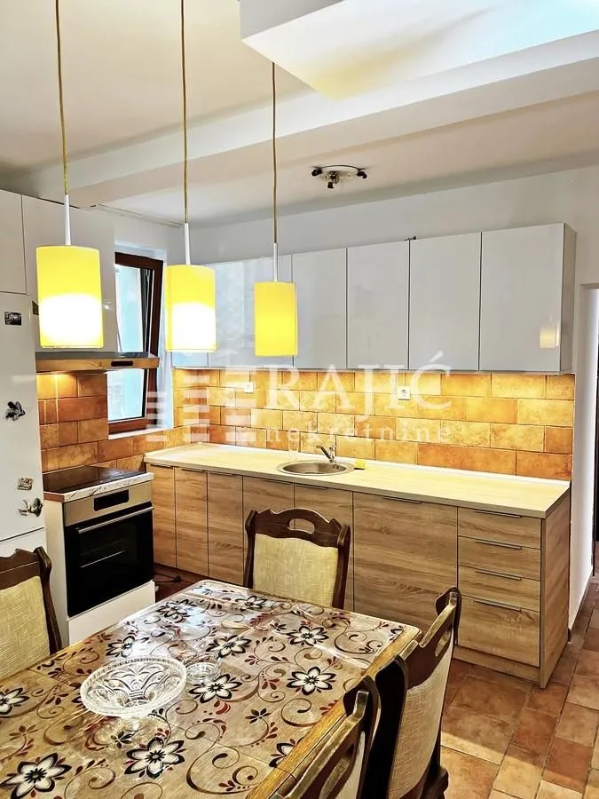 Kitchen with a dining area and wooden elements.
