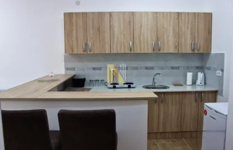 Smaller kitchen with wooden elements and a bar counter. - image 10