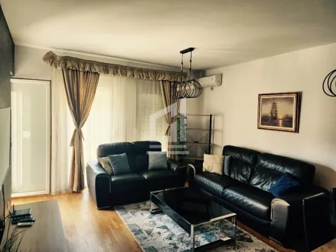 Dnevna soba sa crnim kožnim garniturama i trpezarijskim stolom. - image 2