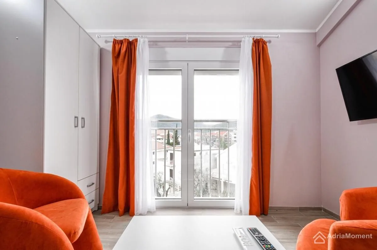 Living room with orange armchairs and access to the terrace.