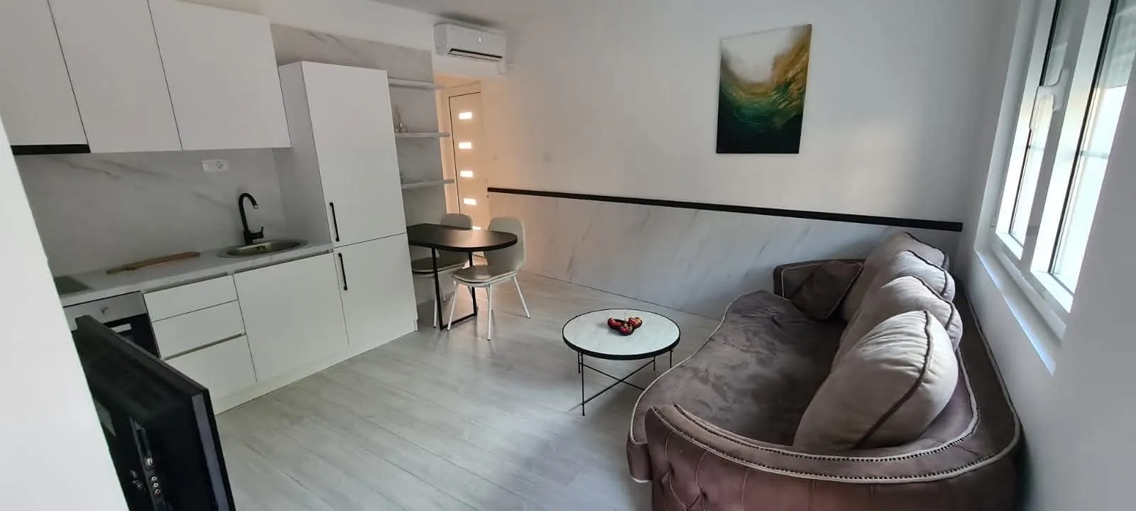 Living room with kitchen and dining area in a modern apartment.