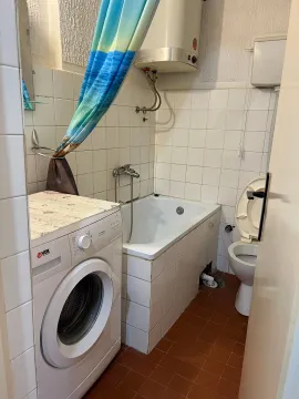 Manje kupatilo sa kadom, toaletom i veš mašinom. - image 10