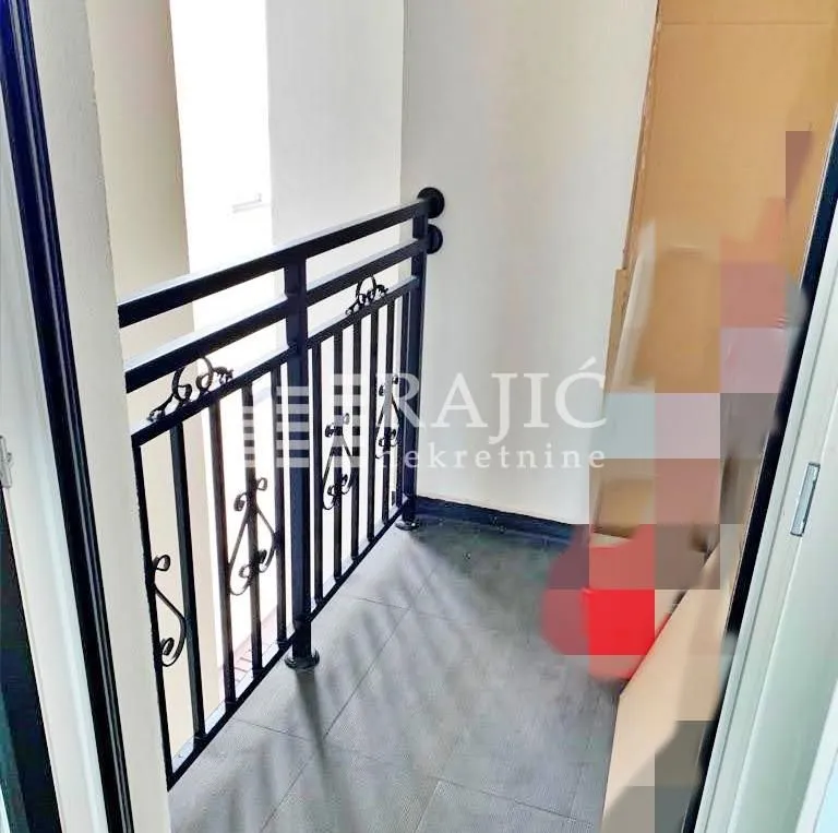 Small covered balcony with metal railing.