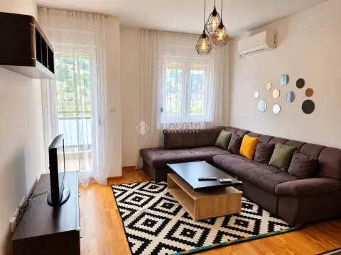 Living room with a sofa, coffee table, and TV unit. - image 2