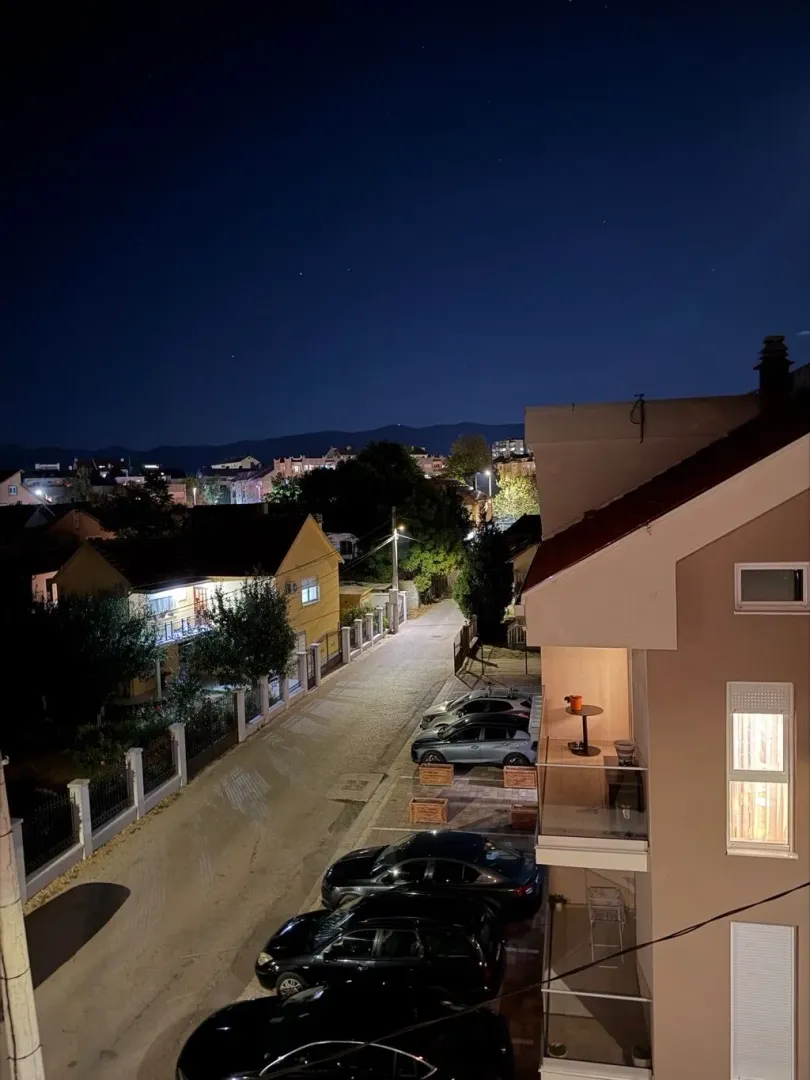 Noćni pogled sa terase na ulicu i okolne kuće.