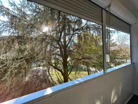 Pogled sa balkona na zeleno dvorište i drveće. - image 6